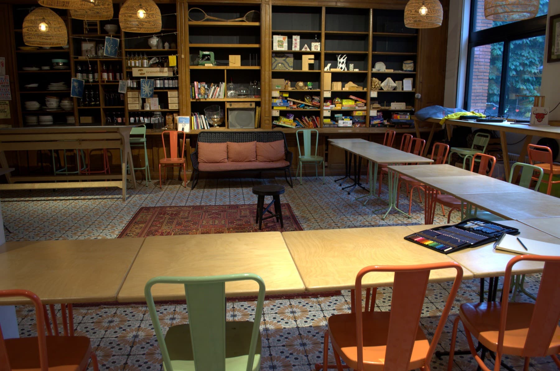 La salle de La Tréso, tiers-lieu, chaises terracotta et étagères de livres